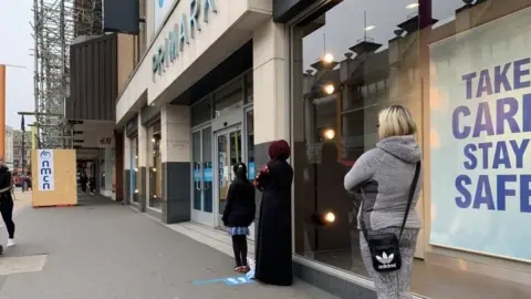 BBC People queuing at shops in Leicester