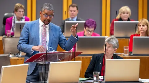 Senedd Commission Vaughan Gething addressing the Senedd