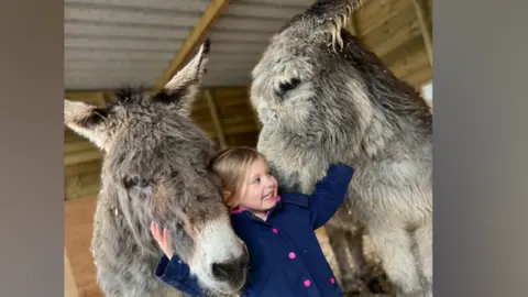 Amy Doran Amy's daughter with the two donkeys