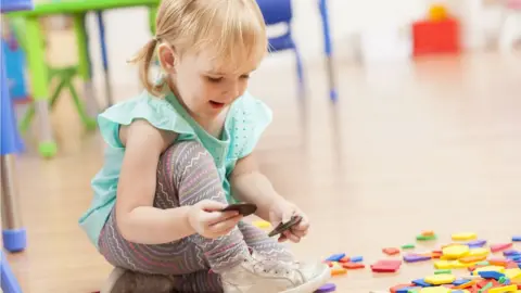 Getty Images A girl plays with toys