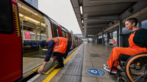 TfL A wheelchair user using a bridging device