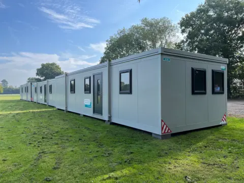 Shaun Whitmore/BBC A temporary classroom that looks like a portacabin has been put in the school grounds.