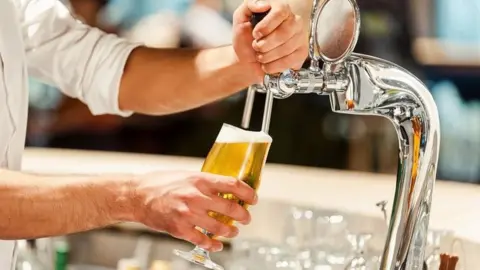 Getty Images Barman pouring beer