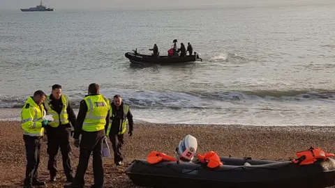 Lewis Morris Border force officials by a dinghy