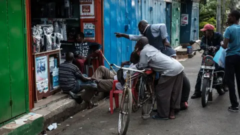 AFP People watch live broadcast as Uhuru Kenyatta is declared the winner following presidential re-election results by Kenya's Independent Electoral and Boundaries Commission (IEBC) on TV at a local electrical shop in Kisumu, on 30 October 2017