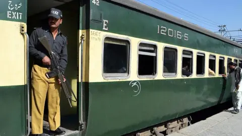 Getty Images A Pakistani policeman stands on a train before departure at a railway station in Quetta on April 9, 2014