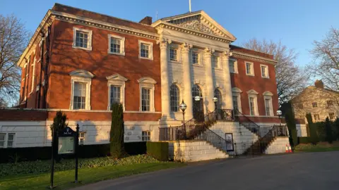 Warrington Town Hall in Warrington, Cheshire, is a large Grade I- listed building designed in the Palladian style by renowned architect James Gibbs in 1750. It is built from red bricks and white stone, with several columns.