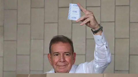 Getty Images Venezuelan opposition presidential candidate Edmundo Gonzalez Urrutia shows his ballot as he votes at the Santo Tomas de Villanueva school in Caracas during the presidential election on July 28, 2024.