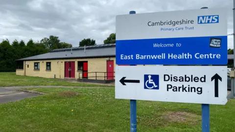 Phil Shepka/BBC Sign outside of East Barnwell Health Centre