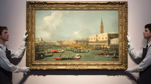 Art handlers hold a painting by Canaletto entitled Venice, the Return of the Bucintoro on Ascension Day