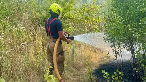 Policía de Leicestershire: Un bombero extingue un incendio en un pastizal en Aylestone Meadows.