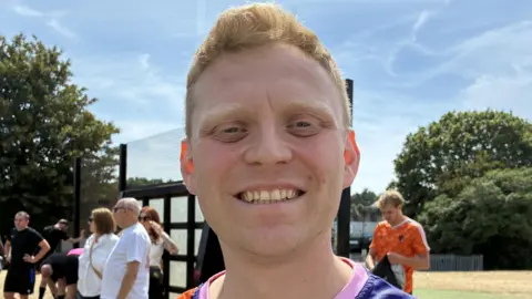 Cathy Killick/BBC A man with short strawberry-blonde hair smiles at the camera