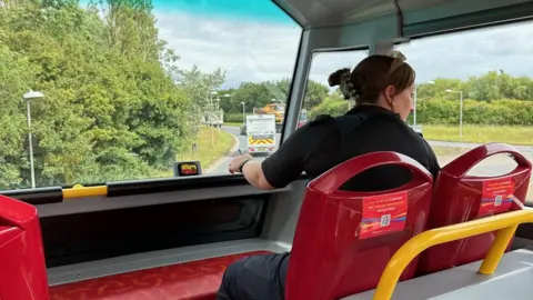 A police officer on the top deck of a bus in Cambridge