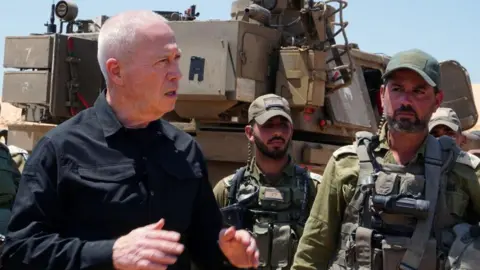 Yoav Gallant (L) speaking with troops on the border between Israel and Gaza Strip