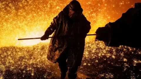 Getty Images A steelworker tapping the blast furnace