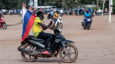 AFP Een motorrijder draagt ​​een Russische vlag