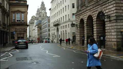 Reuters A woman walks across Water Street after it was cleaned following an incident where a car plowed into a crowd of Liverpool fans during a parade