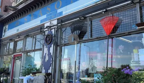 The exterior of All Seasons DIY store in Smethwick, with DIY items like rakes and mops hanging from the windows