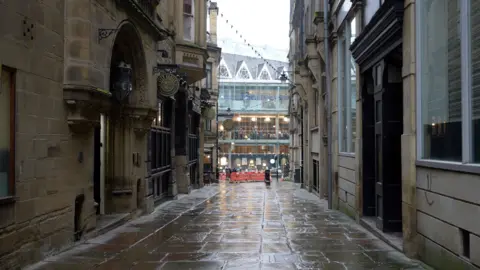 Alleyway in Bradford with City Vaults pub sign on the left.