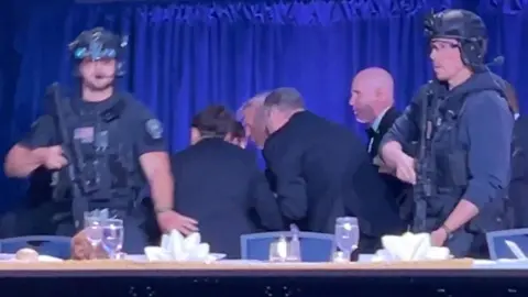 Reuters Donald Trump is taken off stage with heavily armed Secret Service personnel in front
