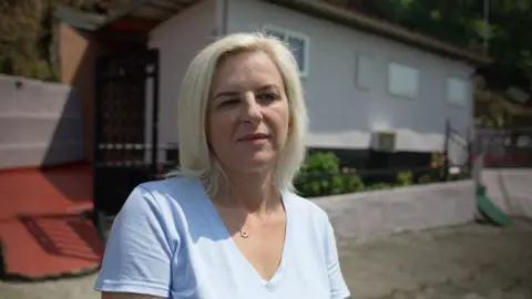 Maria Barbos in front of her home