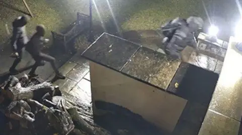 Nottinghamshire Police CCTV of three men in dark clothing in a garden