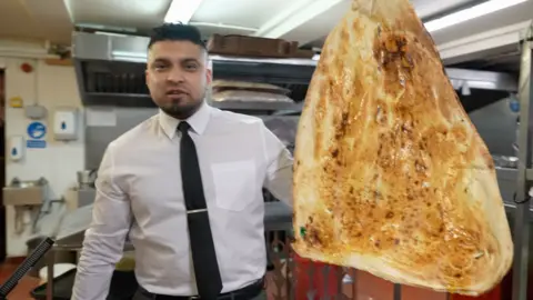 Samad Iqbal from Akbar's in Bradford showcasing their iconic large family naan.