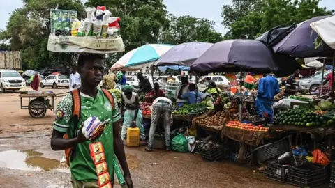 Getty Images A man walks through a market in Niamey