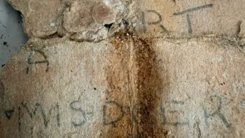 Alex Farrow Back of the note which reads THOU ART A MISDOER - written in faint black ink on, what is now, a discoloured note. 