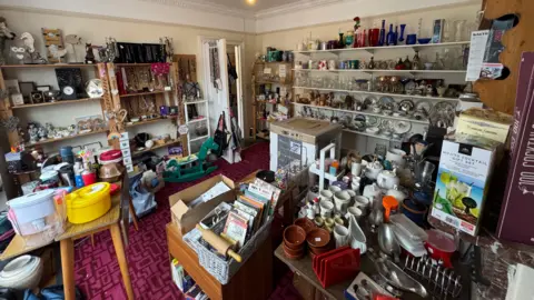 George King/BBC A photo showing a large room filled with donated charity shop items
