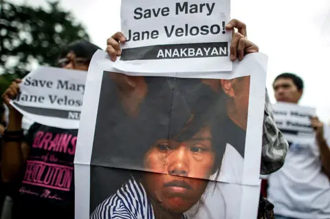 Getty Images Students hold placards and a picture of Mary Jane Fiesta Veloso during a protest near the Malacanang Palace in Manila on 13 September 2016.