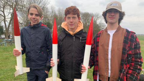 Three teenagers with rockets