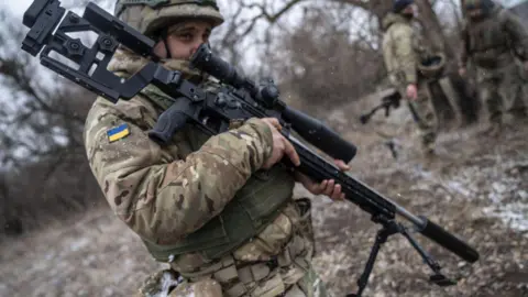 Ukrainian soldier from a sniper unit with a Savage 110 elite prestige 338 prepares to fire at a shooting range in Kharkiv region, Ukraine, on March 18, 2025.