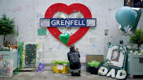 A member of the public at the memorial at the base of Grenfell Tower