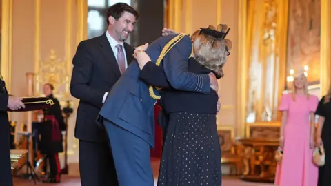 PA Media Wendy Daunt OBE hugging the Prince of Wales during an investiture ceremony at Windsor Castle