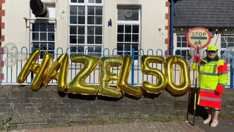 Pentyrch Primary School Hazel Davies with celebration balloons outside school