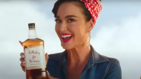 Capitol Records Katy Perry in the Woman's World video dressed as Rosie the Riveter, drinking 'Whiskey for Women'