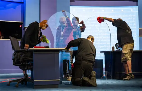 EPA Workers prepare plexiglass on stage before the Vice President debate