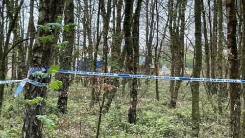 BBC Police tent and cordon wrapped around trees