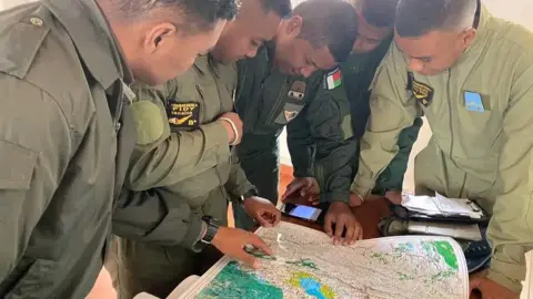 www.defense.gov.mg Officers tasked with hunting the cattle rustlers looking at a map in Madagascar - 30 July 2022