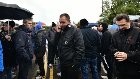 Pacemaker george Brash of the Unite trade union talks on his phone outside the Wrightbus factory