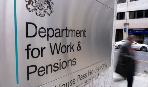 Getty Images An out-of-focus person walks down a street with the sign for the Department for Work and Pensions in the foreground, outside Caxton House in London on 19 February