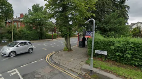 The junction between Street Lane and Allerton Avenue a suburban street with green hedges and a bus stop