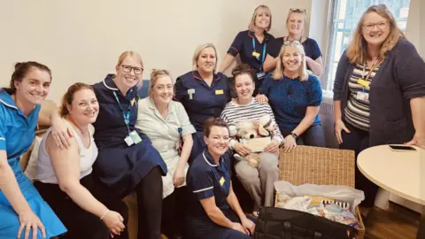 Family photograph Group photograph of maternity staff wearing uniforms with Jenni Hayes picture in the centre