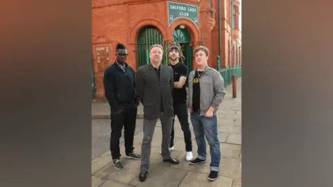 Getty Images Peter Hook poses young people from Salford as they met with Manchester United star Owen Hargreaves and local band Kid British on Tuesday as music and football came together at the iconic landmark and youth venue Salford Lads Club. 