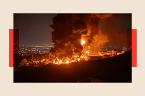 Getty Images Fire and smoke rise into the sky after an Israeli attack on the Shahran oil depot on 15 June 2025 in Tehran, Iran.