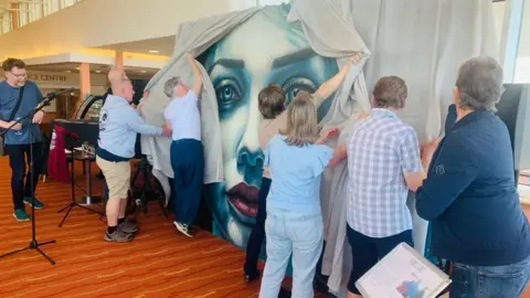 La Vida Liverpool A group of six people unveil the mural