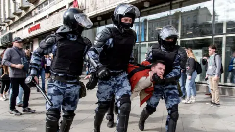 Getty Images Police officers detain a man during an unsanctioned rally in the centre of Moscow, Russia, 3 August 2019