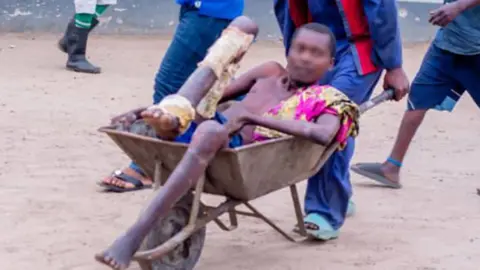 DR Congo Ministry of Justice A man being pushed in a wheelbarrow