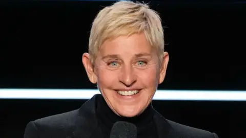 Getty Images Ellen DeGeneres w czarnej kurtce, uśmiechniętej i przemawiającej w Carol Burnett: 90 lat śmiechu + miłość - sezon 2023